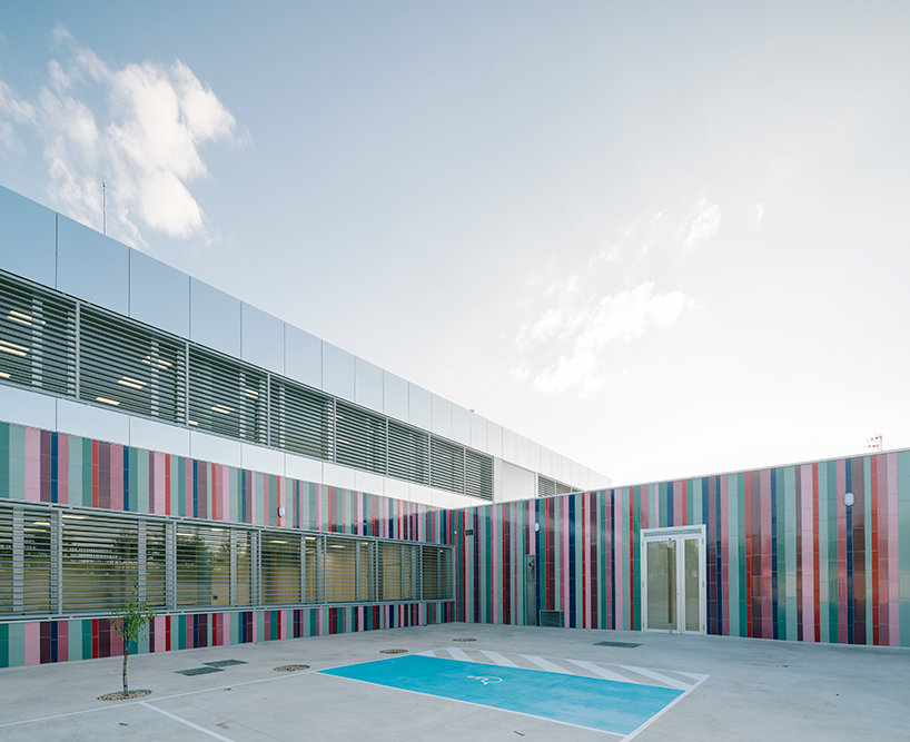 ABLM combines reflective mirrors with strips of vibrant colorful ceramic in school façade