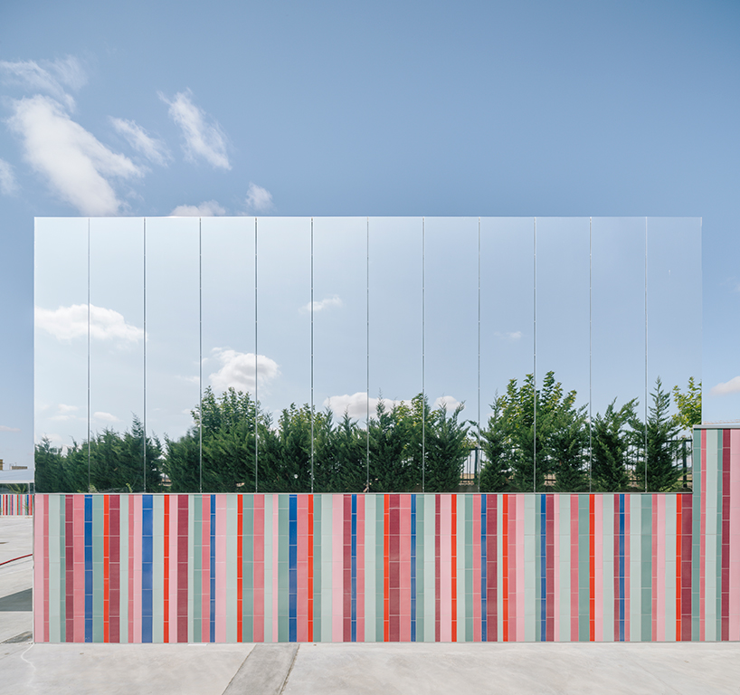 ABLM combines reflective mirrors with strips of vibrant colorful ceramic in school façade