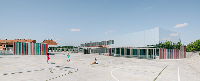 ABLM combines reflective mirrors with strips of vibrant colorful ceramic in school façade