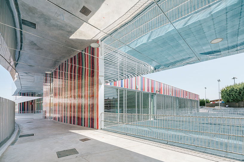 ABLM combines reflective mirrors with strips of vibrant colorful ceramic in school façade