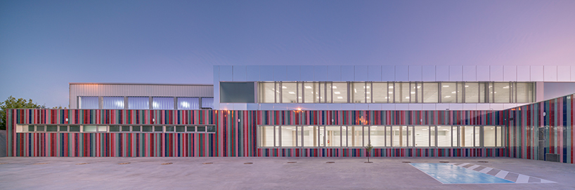 ABLM combines reflective mirrors with strips of vibrant colorful ceramic in school façade