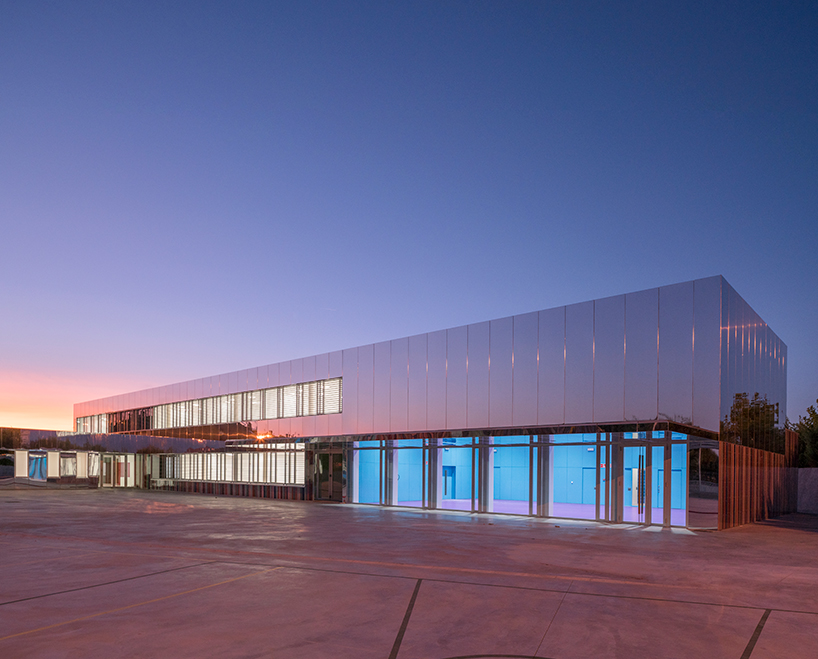 ABLM combines reflective mirrors with strips of vibrant colorful ceramic in school façade