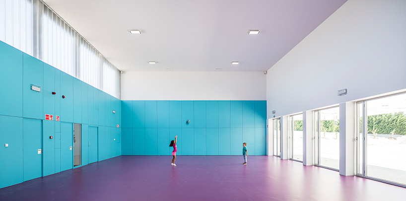 ABLM combines reflective mirrors with strips of vibrant colorful ceramic in school façade