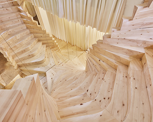 acme installs massive timber staircase with winding mirrors in its london studio