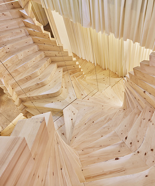 acme installs massive timber staircase with winding mirrors in its london studio