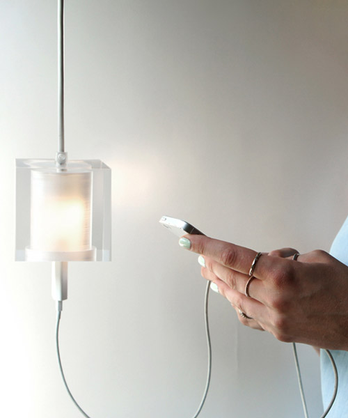 this suspending workspace lamp allows users to charge their devices simultaneously