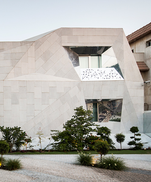 rock house by AGi architects is clad with concrete that looks like origami
