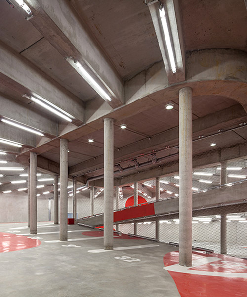 anonyme studio balances the raw structure of an underground parking with red splashes