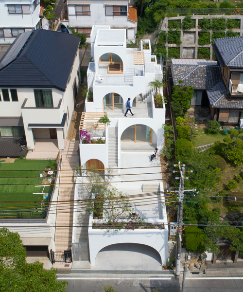 tomhiro hata adds a romanesque façade to narrow, all-white dwelling in kobe