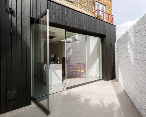 dickson architects extends a victorian house with black timber box in london