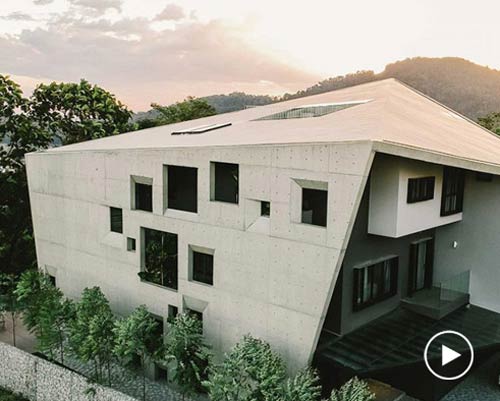 FORMZERO's window house in malaysia relates to nature through its concrete shell