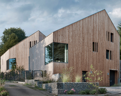 grotto-like, sibling residences elevate the rough expression of unfinished wood