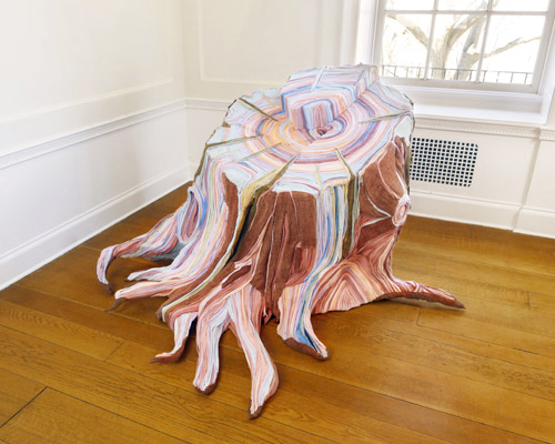artist uses discarded and disused fabric to create intricately layered tree stumps