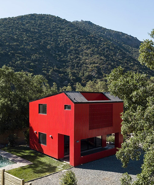 felipe assadi's red modular house contrasts the greenery of its chilean surroundings
