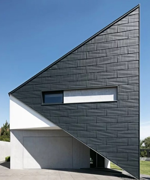 reform architekt's triangular house in poland perfectly fits surrounding environment