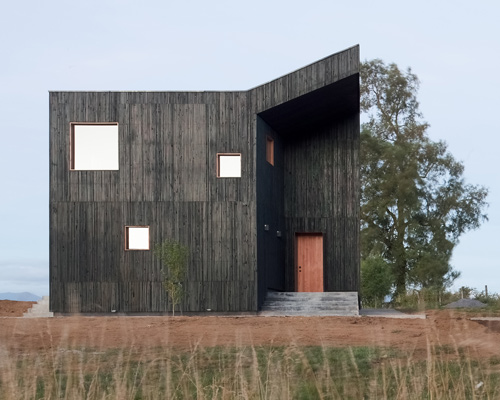 ampuero yutronic manipulates all-black volume to form sculptural hilltop home in chile