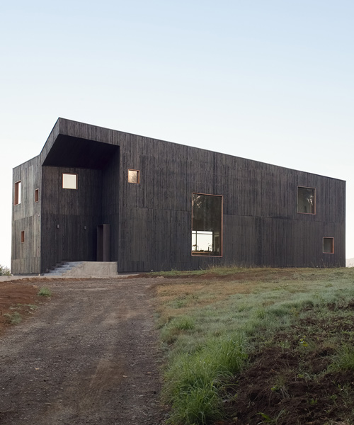 ampuero yutronic manipulates all-black volume to form sculptural hilltop home in chile
