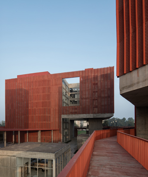 all-red student housing in india resembles rocky cliffs and shaded valleys