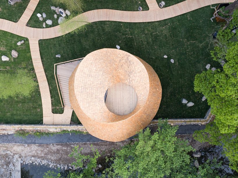 a curved roof dictates the circular sequence of spaces in 