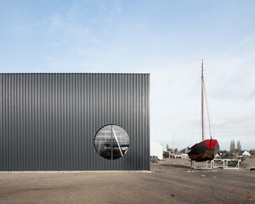 geometric shapes cut through the industrial facade of BETA's amsterdam boat hangar