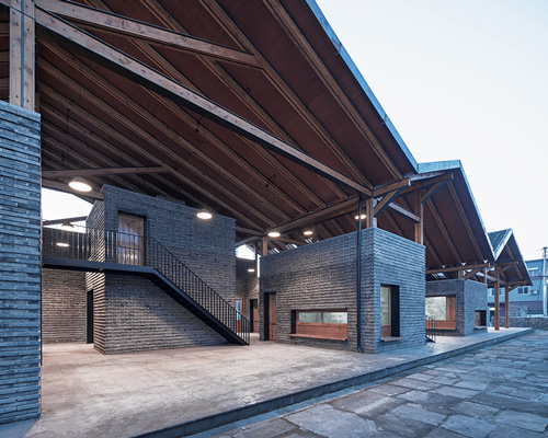 line+ studio's chinese village activity center sits under a zig-zag roof in steel and timber