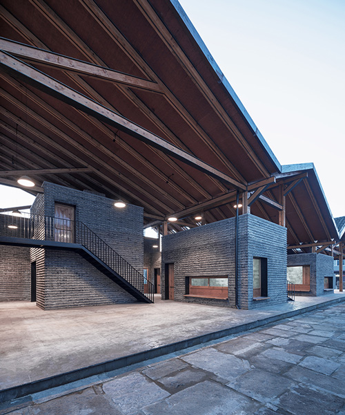 line+ studio's chinese village activity center sits under a zig-zag roof in steel and timber