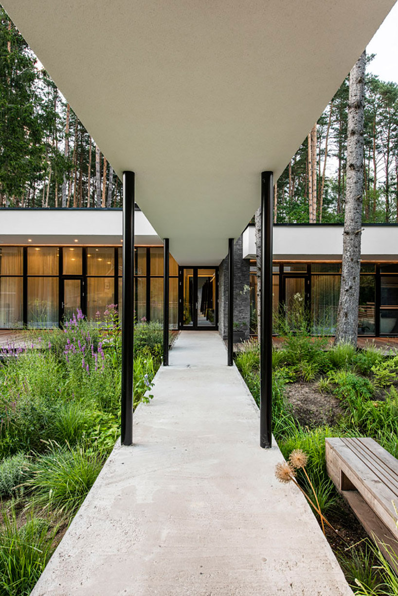 modernist house in lithuanian pine forest bridges a creek, by archLAB