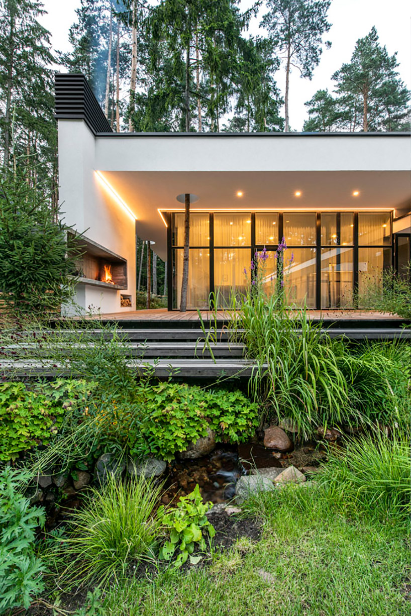 modernist house in lithuanian pine forest bridges a creek, by archLAB
