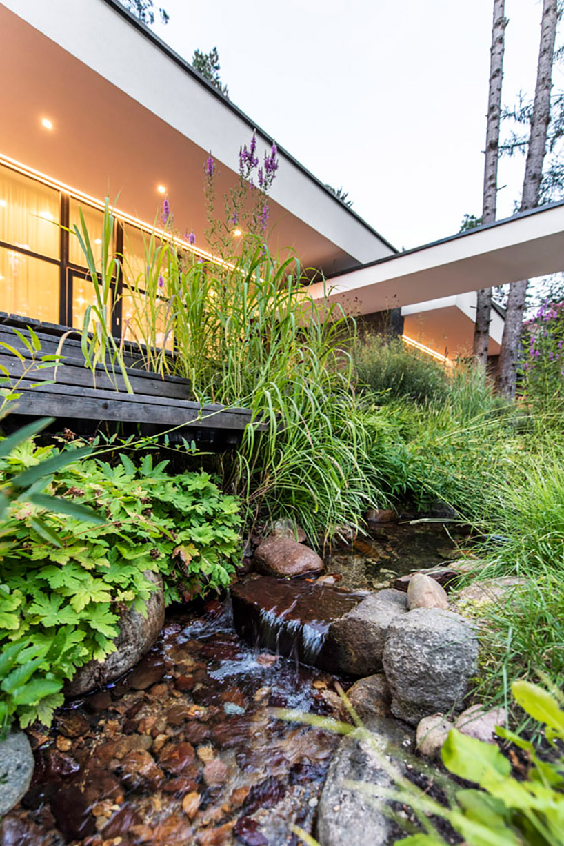 modernist house in lithuanian pine forest bridges a creek, by archLAB