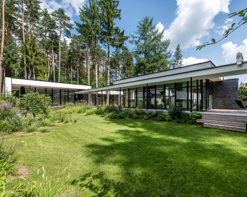 modernist house in lithuanian pine forest bridges a creek, by archLAB