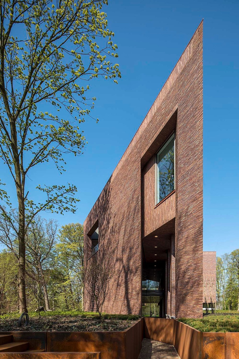 the lisse art museum by KVDK architects sits on top of a historic dike in the netherlands