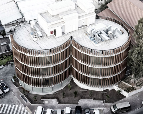 two translucent cylinders of wooden louvres extend the design college campus in ramat gan, by geotectura