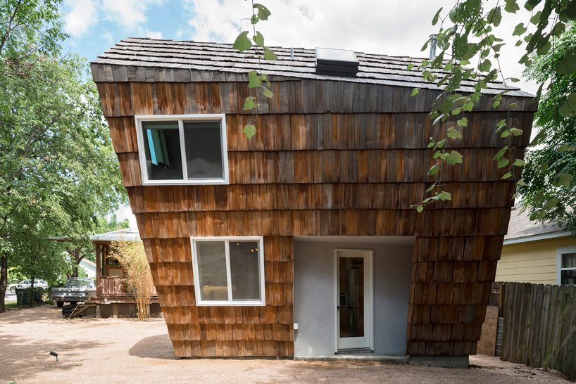 studio 512 clads the angled walls of this texas guesthouse in reclaimed cedar shakes