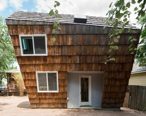studio 512 clads the angled walls of this texas guesthouse in reclaimed cedar shakes