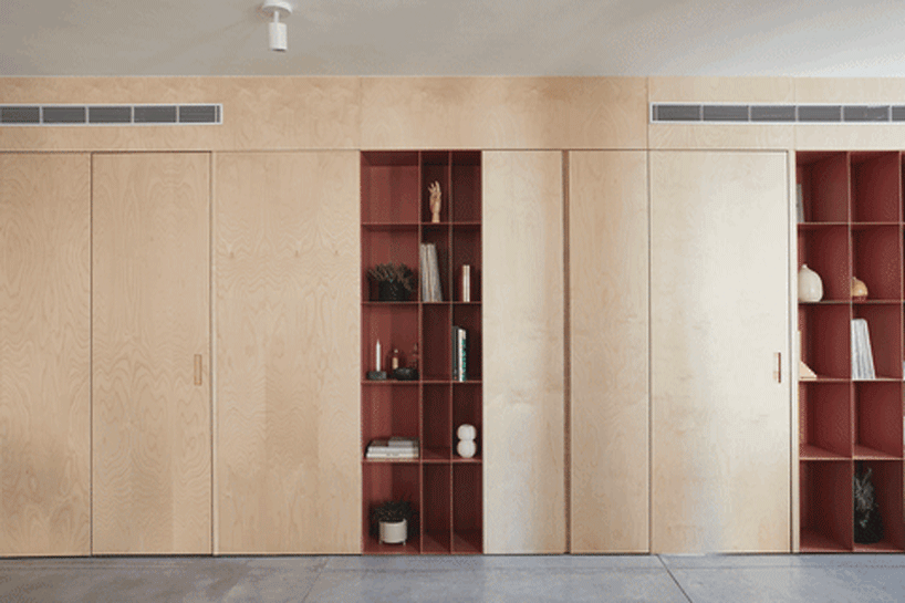 this apartment in tel aviv uses a wooden storage unit to separate private spaces