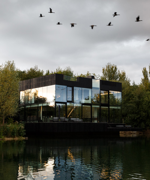 mecanoo completes glass + burnt wood villa on the waterfront of a british lake