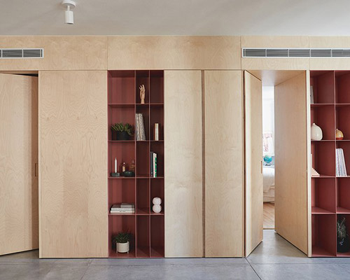 this apartment in tel aviv uses a wooden storage unit to separate private spaces