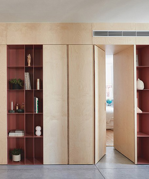 this apartment in tel aviv uses a wooden storage unit to separate private spaces