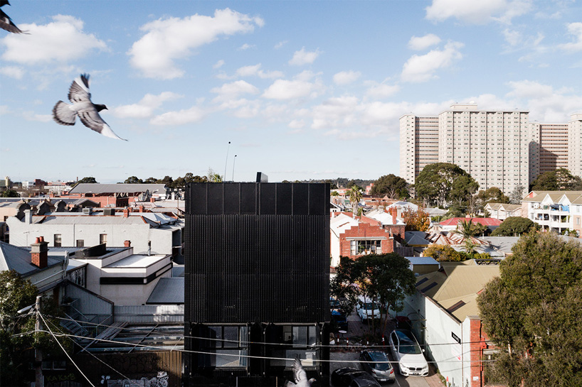 DKO architecture + SLAB architecture add black metal screen façade to vertical dwellings in australia designboom