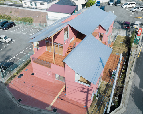 tomoyuki kurokawa tops pink-hued nursery school with a curved roof of laminated wood