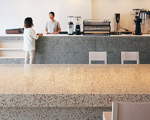 japanese café by arii irie architects is organized around a huge terrazzo table