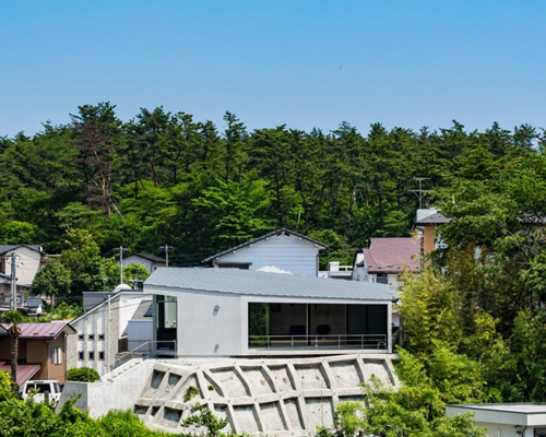ginga architects builds concrete house on top of a retaining wall in japan