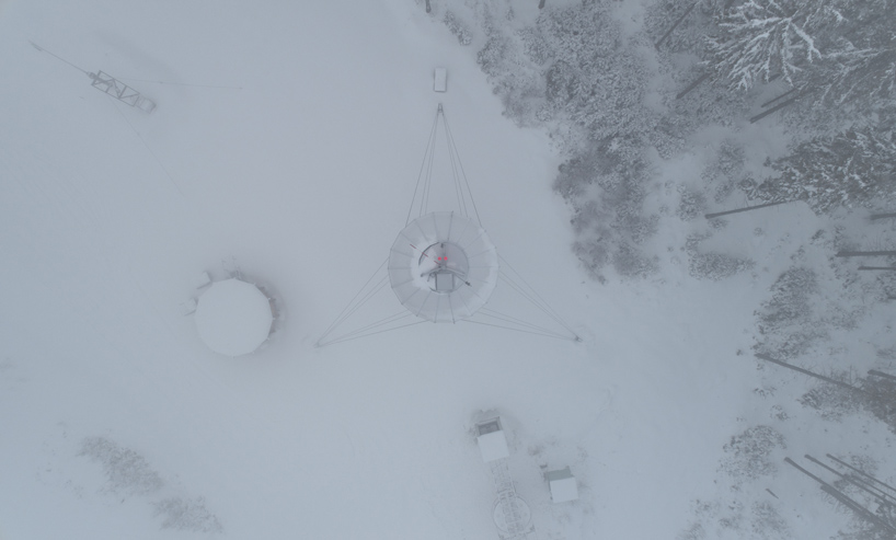 a lookout tower rises above the forested mountains of a czech ski area