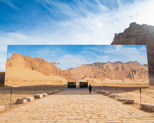 mirrored concert hall appears as a giant mirage in the desert landscape of saudi arabia