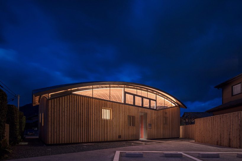 curved wood lattice roof hangs above nasca's blue sky nursery school in ...