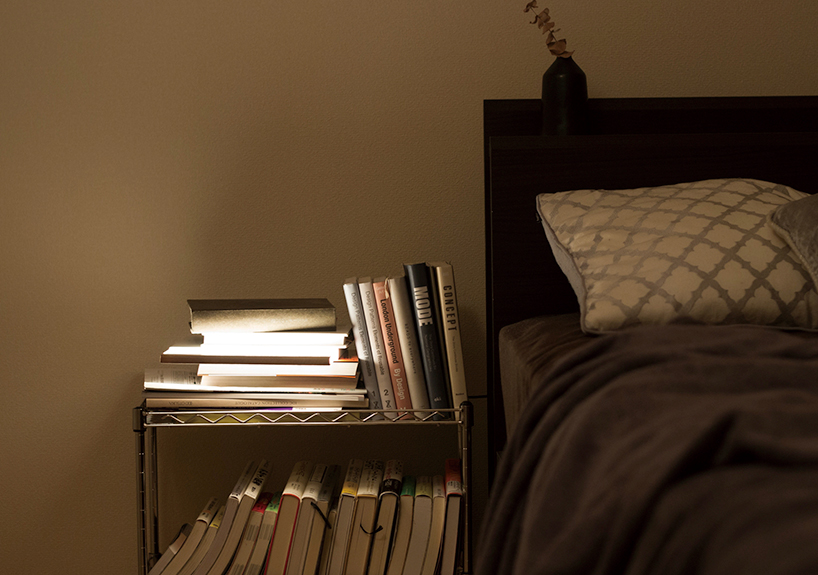 buku malam memancarkan cahaya hangat dan lembut saat ditarik dari rak buku