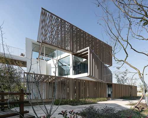 yiduan shanghai interior design adds timber canopy to shipping containers to form office