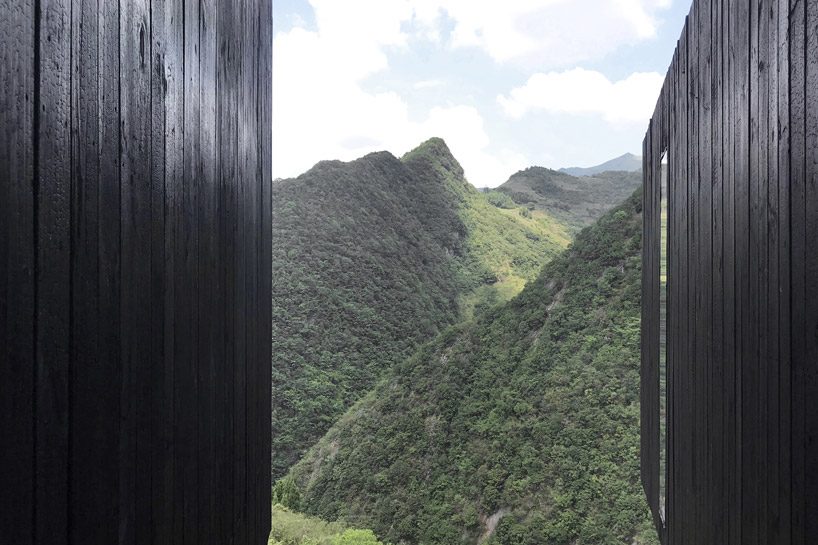 ZJJZ builds charred timber volumes on a hillside in rural china for 'woodhouse hotel' designboom