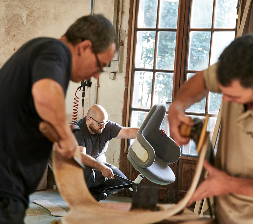 alki lan chair holds self-adjusting mechanisms within clean curving form