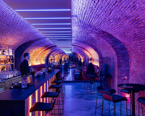 the cavernous, glowing 'bala perdida club' is hidden beneath streets of madrid